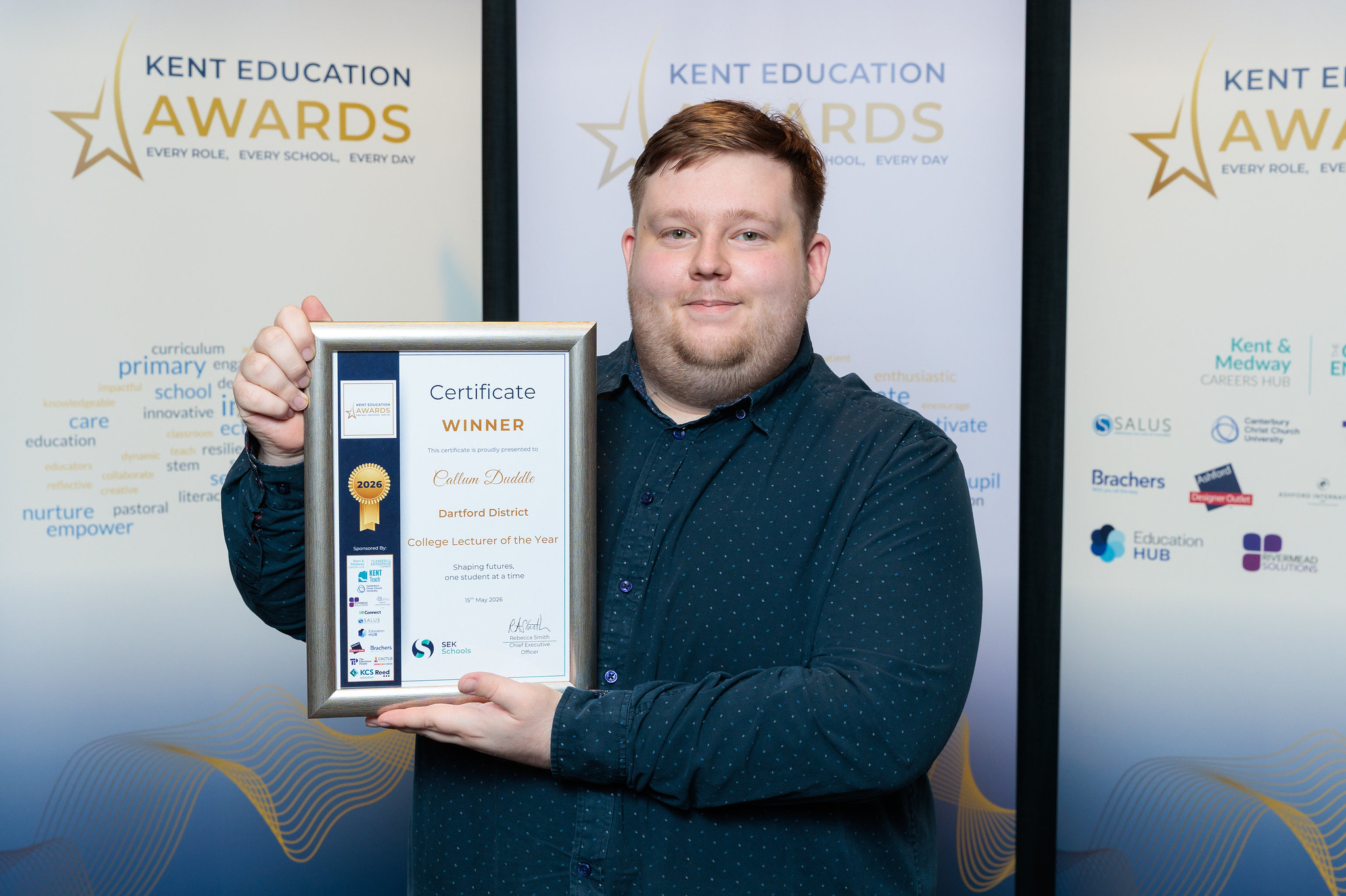 Callum Duddle holds up his Kent Education Award certificate