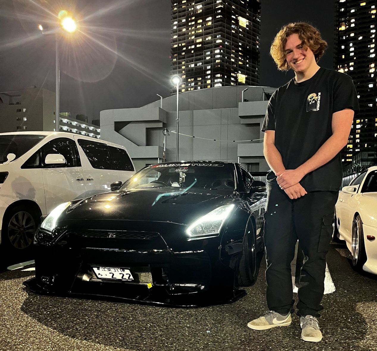Young man standing by car