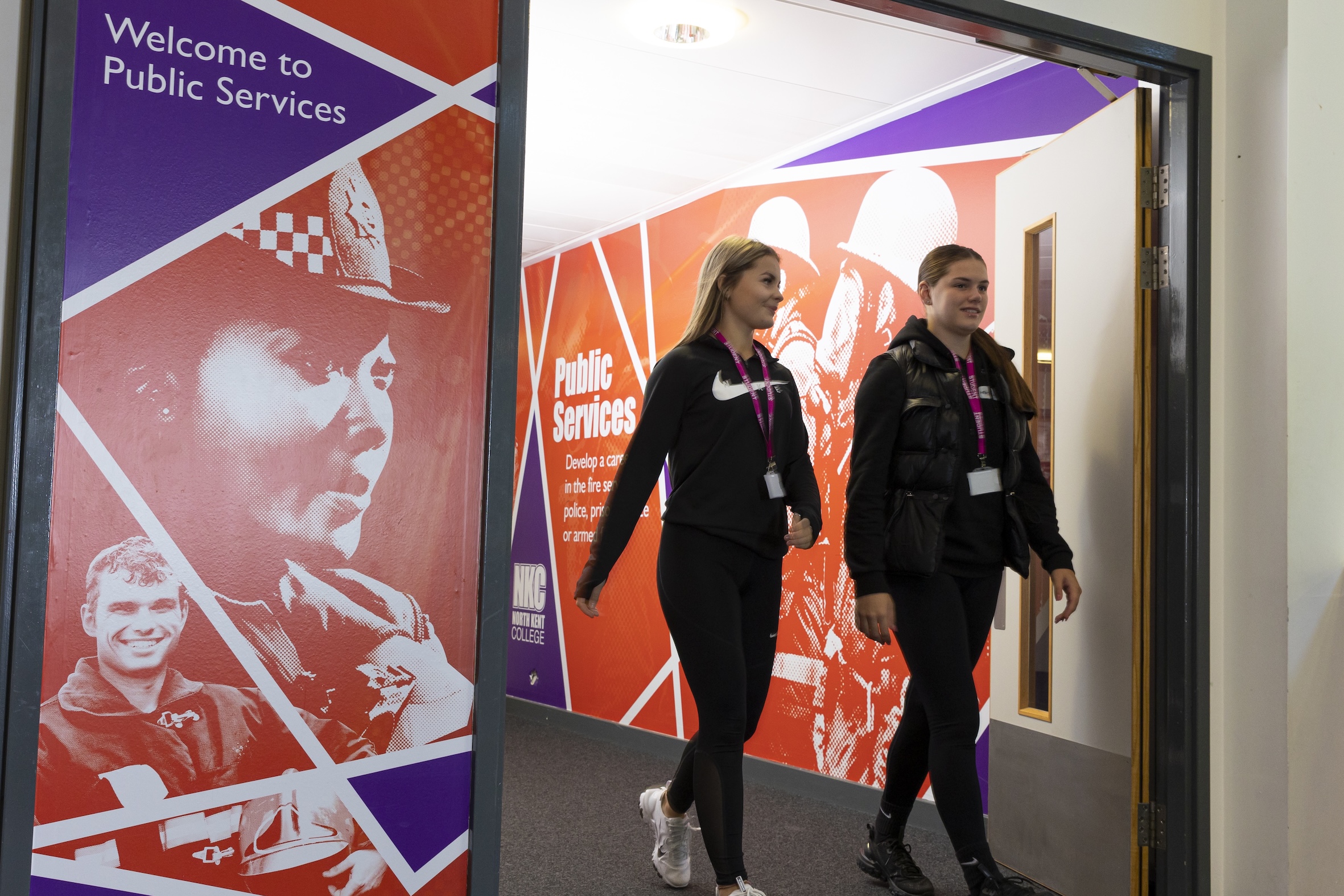 Two students walking next to Public Services signage