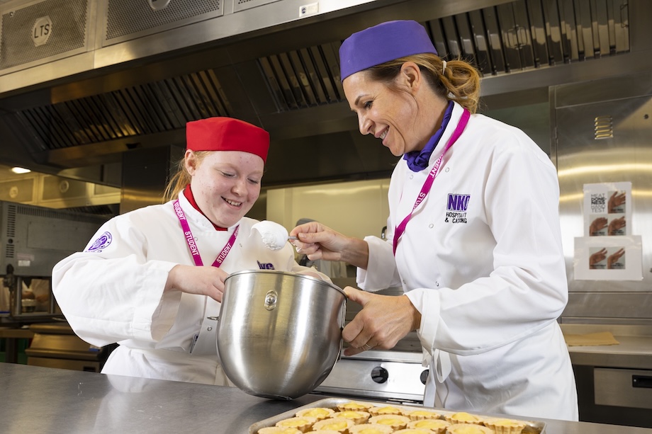 A student chef and tutor prepare a meal in a professional kitchen at NKC Gravesend College